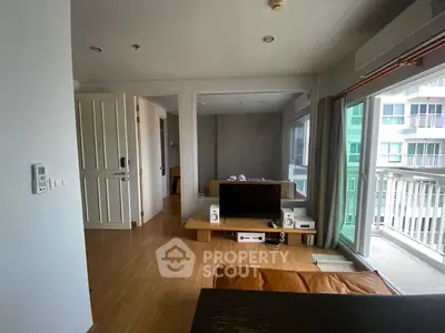 Modern living room with wooden flooring and large window balcony view