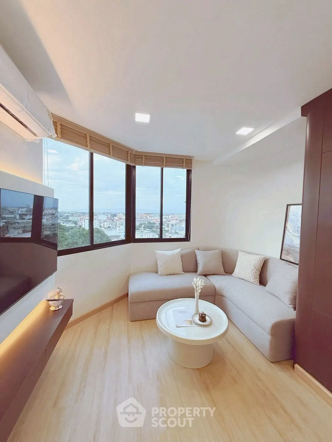 Modern living room with panoramic city view and cozy corner sofa.