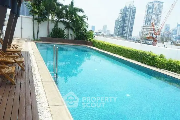 Luxurious rooftop pool with city skyline view in modern urban setting.