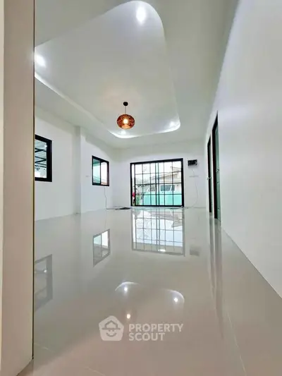 Spacious modern living room with glossy floors and stylish lighting in a contemporary home.