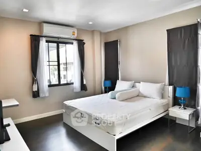 Spacious modern bedroom with large windows and stylish decor in a contemporary home.
