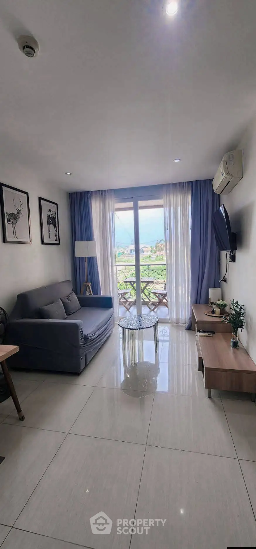 Modern living room with balcony view, stylish decor, and natural light.