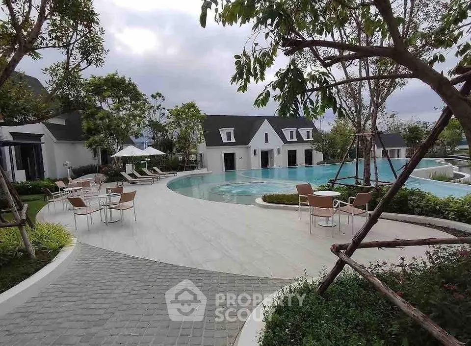 Luxurious outdoor pool area with modern seating and lush greenery, perfect for relaxation and leisure.