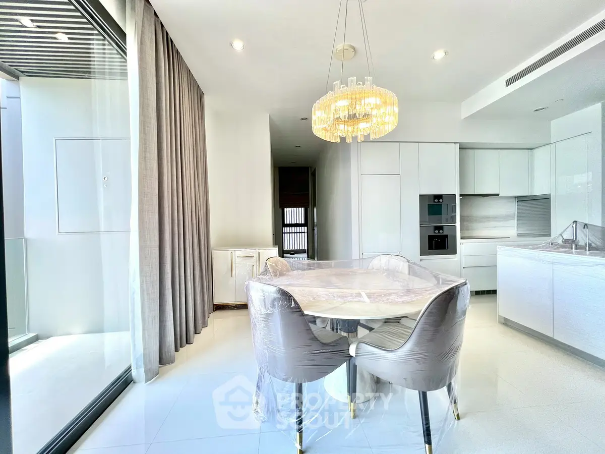 Luxurious modern dining area with elegant chandelier and sleek kitchen design