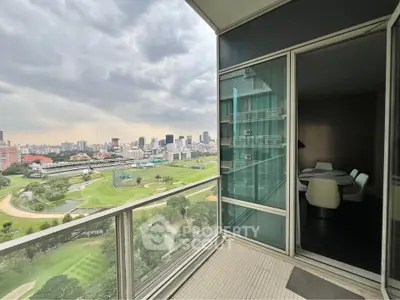 Stunning city view from modern high-rise balcony overlooking lush golf course.