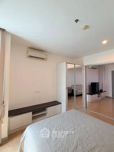 Modern bedroom with mirrored closet and air conditioning in a stylish apartment.