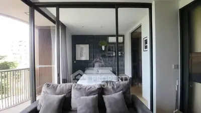 Modern apartment with cozy bedroom and balcony view, featuring stylish decor and natural light.