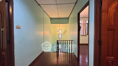 Charming hallway with wooden floors and elegant chandelier lighting