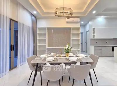 Elegant dining area with modern chandelier and open kitchen layout in a luxurious home.