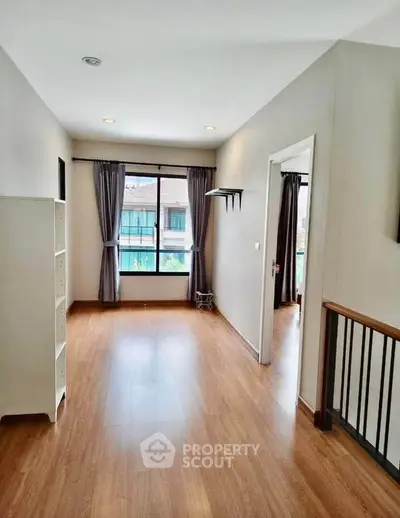 Spacious and bright interior with wooden flooring and large window, perfect for modern living.