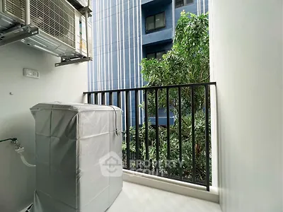 Modern balcony with air conditioning unit and lush greenery view in urban setting.