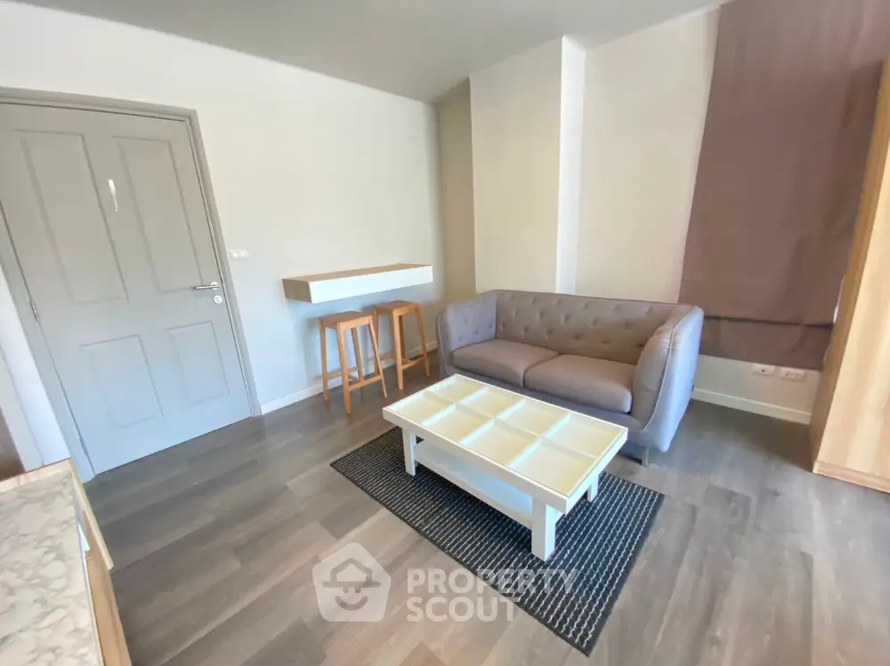 Cozy living room with modern sofa and stylish coffee table in a compact apartment.