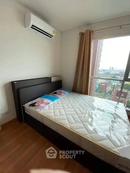 Modern bedroom with large window and city view, featuring a comfortable bed and air conditioning.