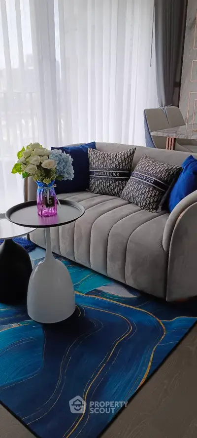Stylish living room with modern sofa, vibrant blue rug, and elegant decor