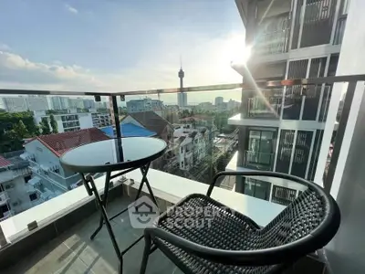Charming balcony with city view and cozy seating, perfect for relaxation.