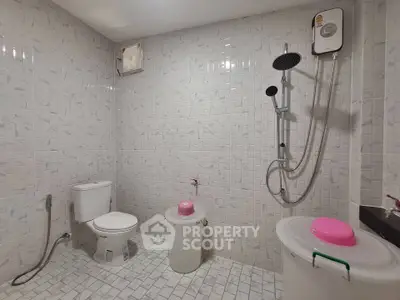 Modern bathroom with shower and toilet in tiled interior