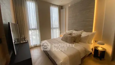 Luxurious modern bedroom with elegant lighting and large windows in a high-rise apartment.