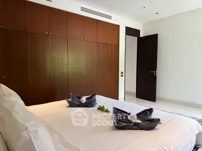 Luxurious bedroom with elegant wooden wardrobes and stylish decor in a modern apartment.