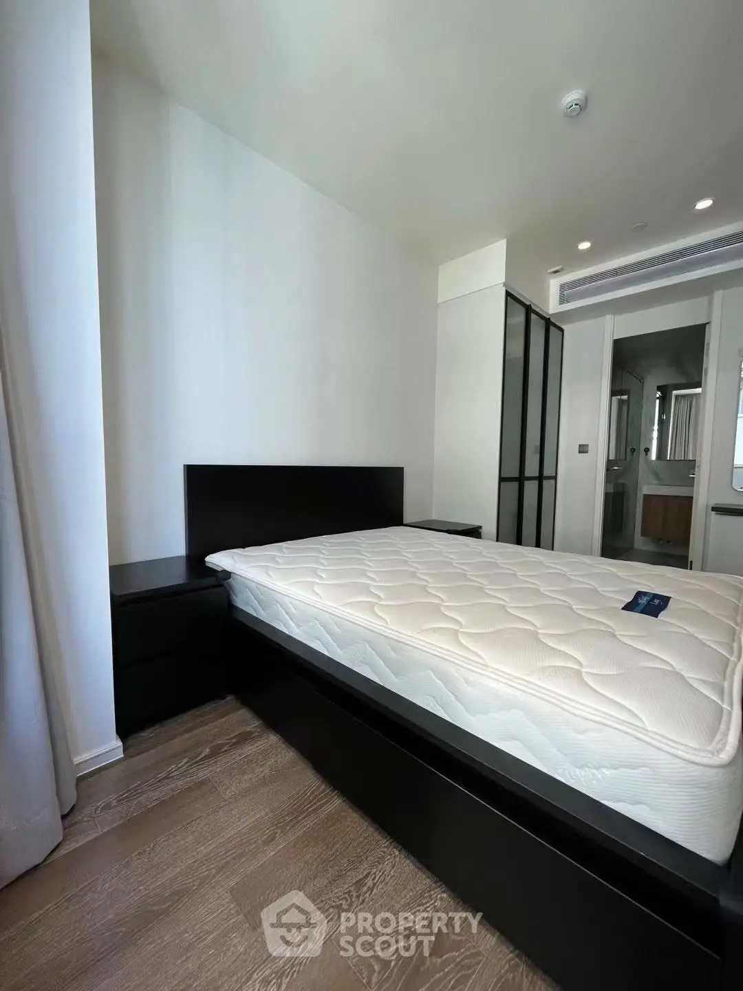 Modern bedroom with sleek design and natural light, featuring a comfortable bed and stylish furnishings.