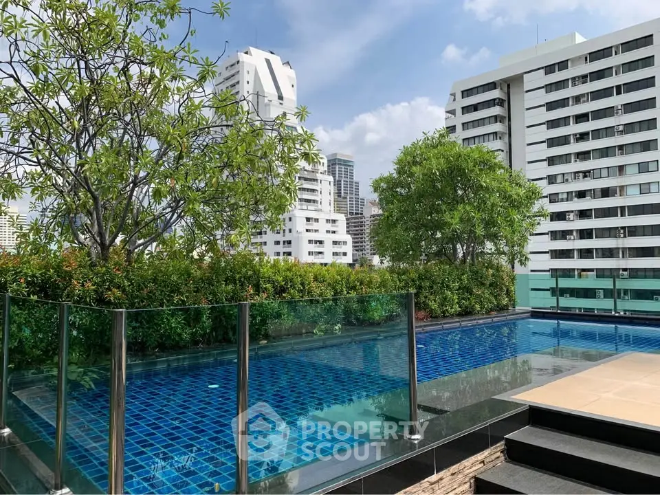 Luxurious rooftop pool with stunning city views and lush greenery in a modern urban setting.