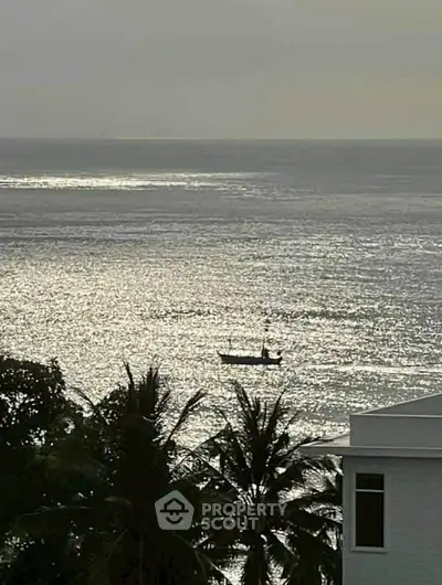 Stunning ocean view from a coastal property with palm trees and serene waters.