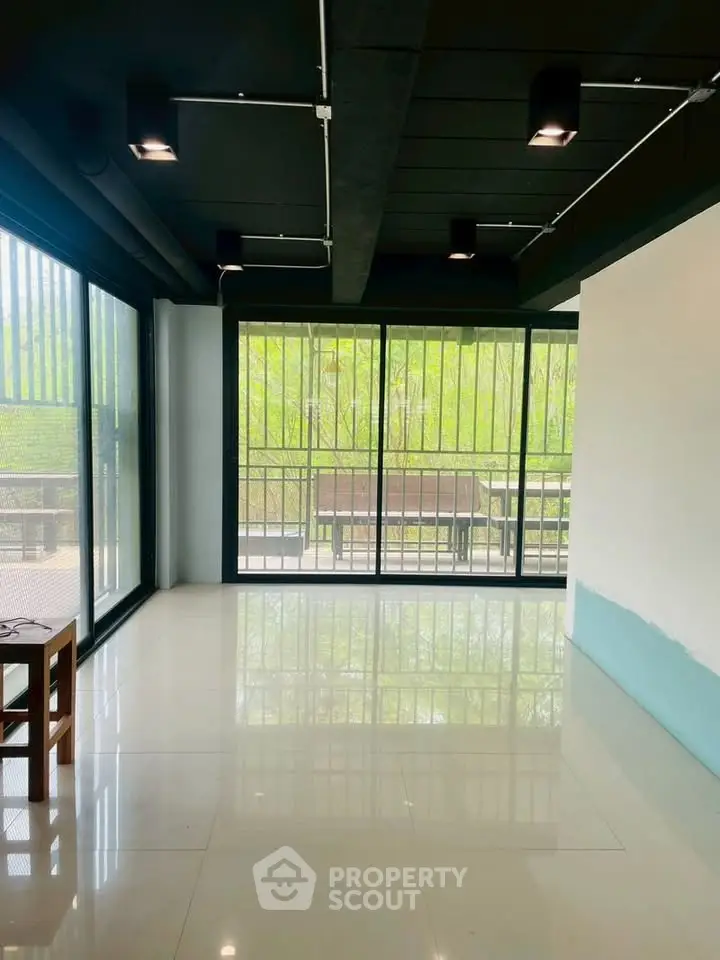 Spacious modern room with large windows and balcony view