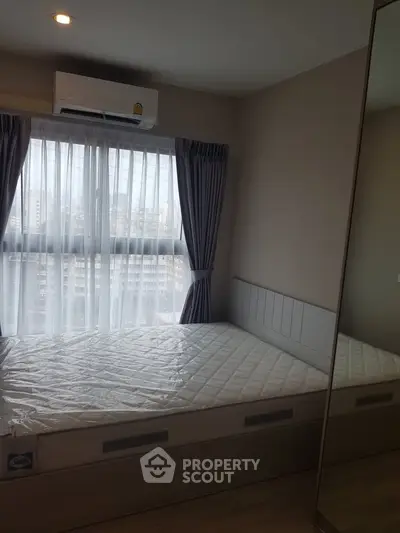 Modern bedroom with large window and city view, featuring a comfortable bed and air conditioning.