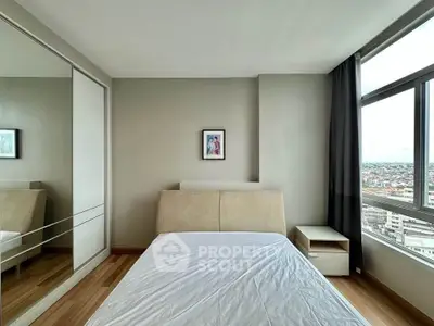 Modern bedroom with large window offering city view, mirrored closet, and minimalist decor.
