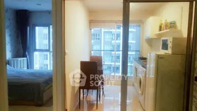 Cozy apartment with open kitchen and bedroom, featuring modern appliances and large windows for natural light.