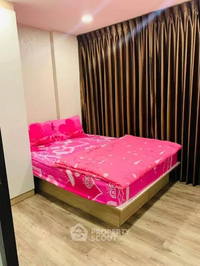 Cozy bedroom with vibrant pink bedding and elegant brown curtains, perfect for a restful retreat.