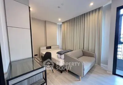 Modern bedroom with cozy sofa and desk, featuring floor-to-ceiling curtains and a sleek design.