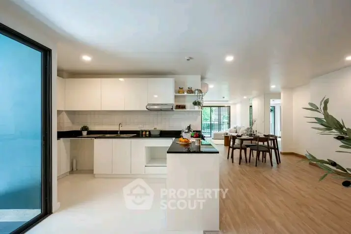 Modern open-layout kitchen and dining area with sleek design and ample natural light.