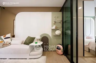 Modern studio apartment with chic decor, featuring a cozy living area with stylish furniture and a glass partition leading to a serene bedroom space.