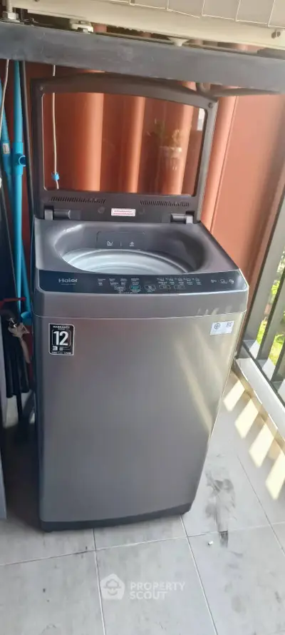 Modern washing machine on a balcony with a scenic view, perfect for urban living convenience.
