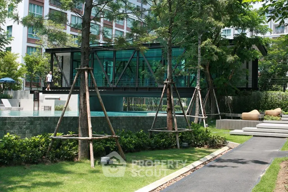 Modern residential building with lush garden and pool, featuring sleek architecture and serene outdoor space.