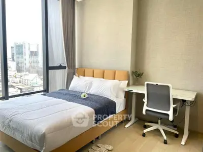 Modern bedroom with city view, featuring a cozy bed and a sleek study desk.