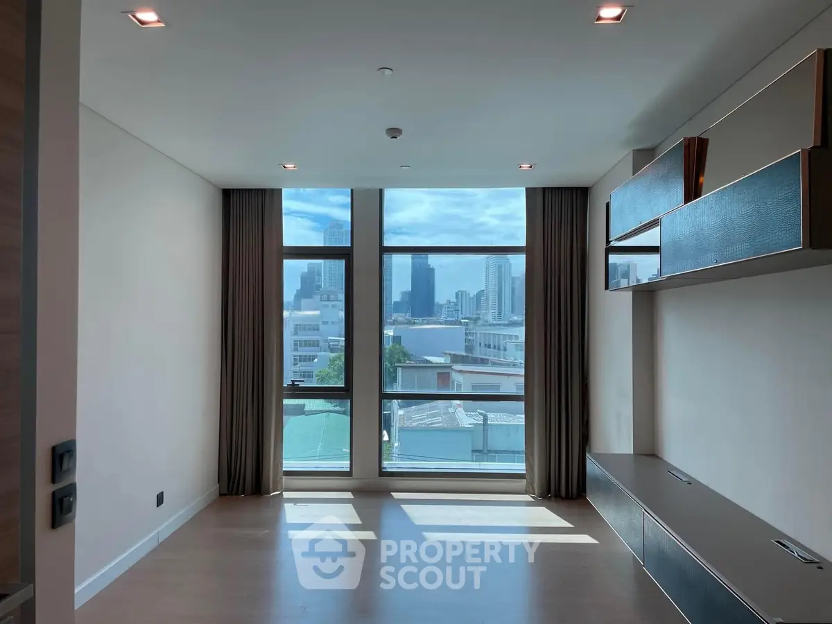 Spacious modern living room with large windows offering stunning city views, perfect for urban living.