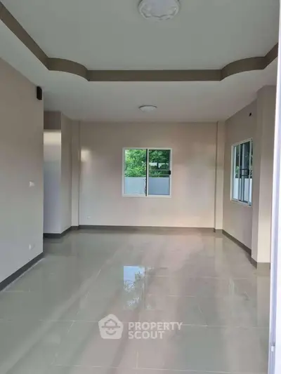 Spacious empty room with large windows and glossy tiled floor, perfect for customization.