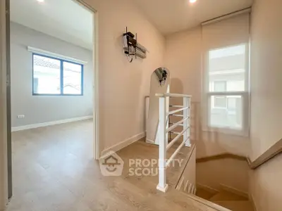 Bright and airy stairway with wooden flooring and modern railing in a contemporary home.