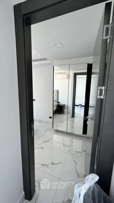 Modern bedroom with mirrored closet doors and marble flooring