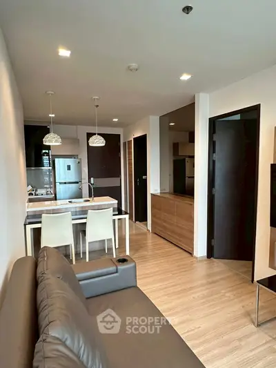 Modern open-plan living room with kitchen featuring sleek design and contemporary furnishings.