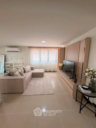 Spacious modern living room with elegant decor and large TV unit, perfect for relaxation and entertainment.