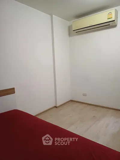 Minimalist bedroom with air conditioning and wooden flooring