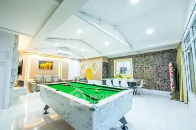 Luxurious living room with pool table and elegant decor, perfect for entertainment.