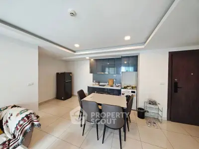 Modern kitchen with dining area and sleek appliances in open layout.