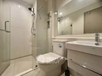 Modern bathroom with glass shower and sleek fixtures in a contemporary apartment.