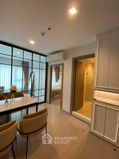 Modern apartment interior with open layout, dining area, and cozy bedroom view.