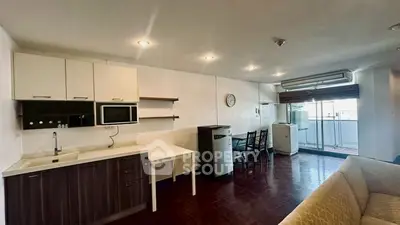 Spacious open-layout living room with modern kitchen and balcony access