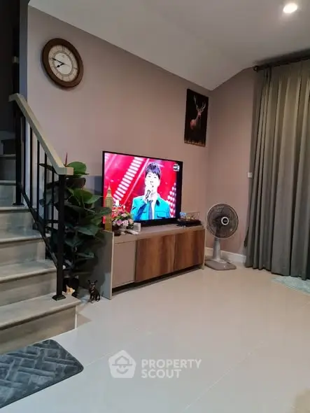 Modern living room with TV, staircase, and stylish decor