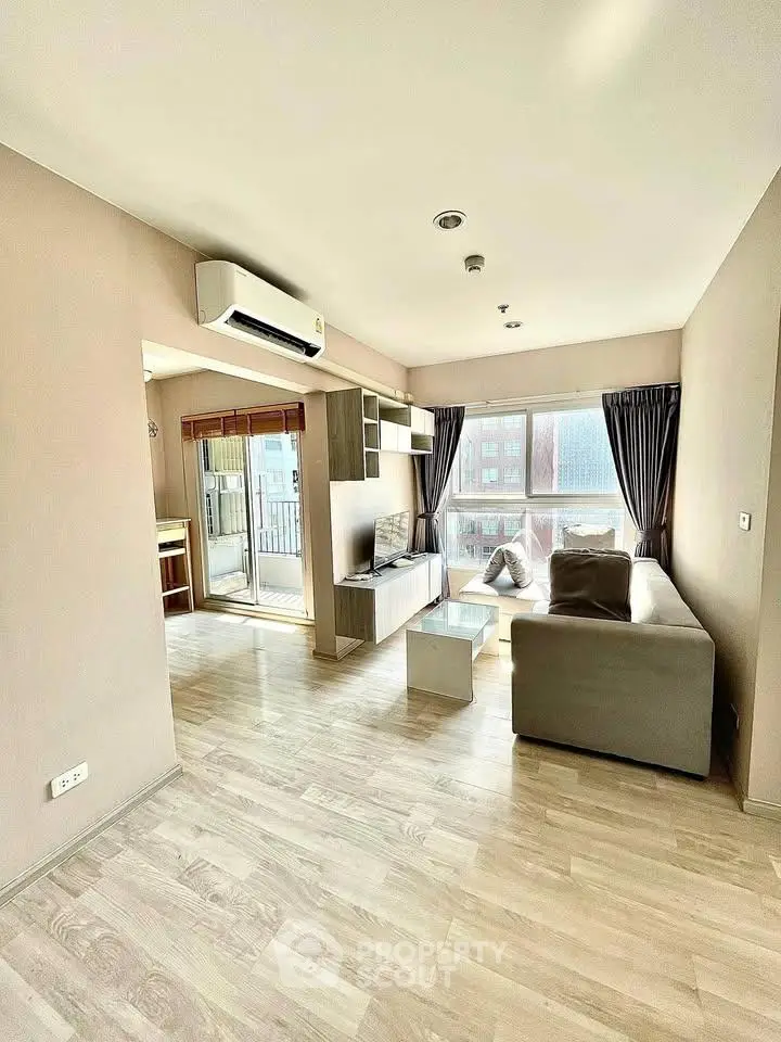 Spacious modern living room with large windows and balcony access in a stylish apartment.